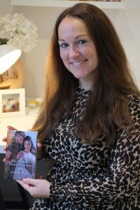 A picture of author Sarah Rodi holding a copy of her Harlequin Historical debut book, The Viking's Stolen Princess.