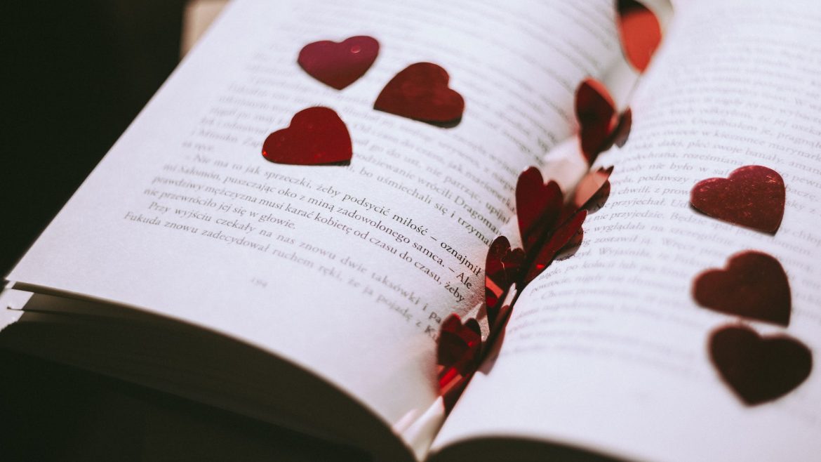 An open book, heart cut outs on top of the book.