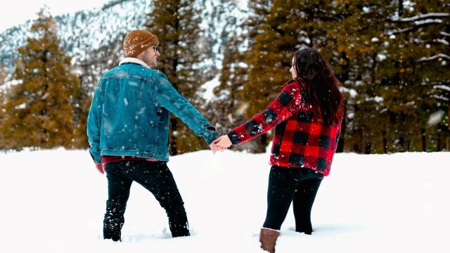 A couple holding hands in the snow.