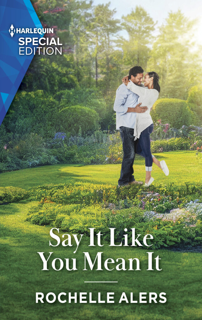 Say It Like You Mean It cover with a casually dressed and smiling man and woman embracing for a kiss in a beautiful garden