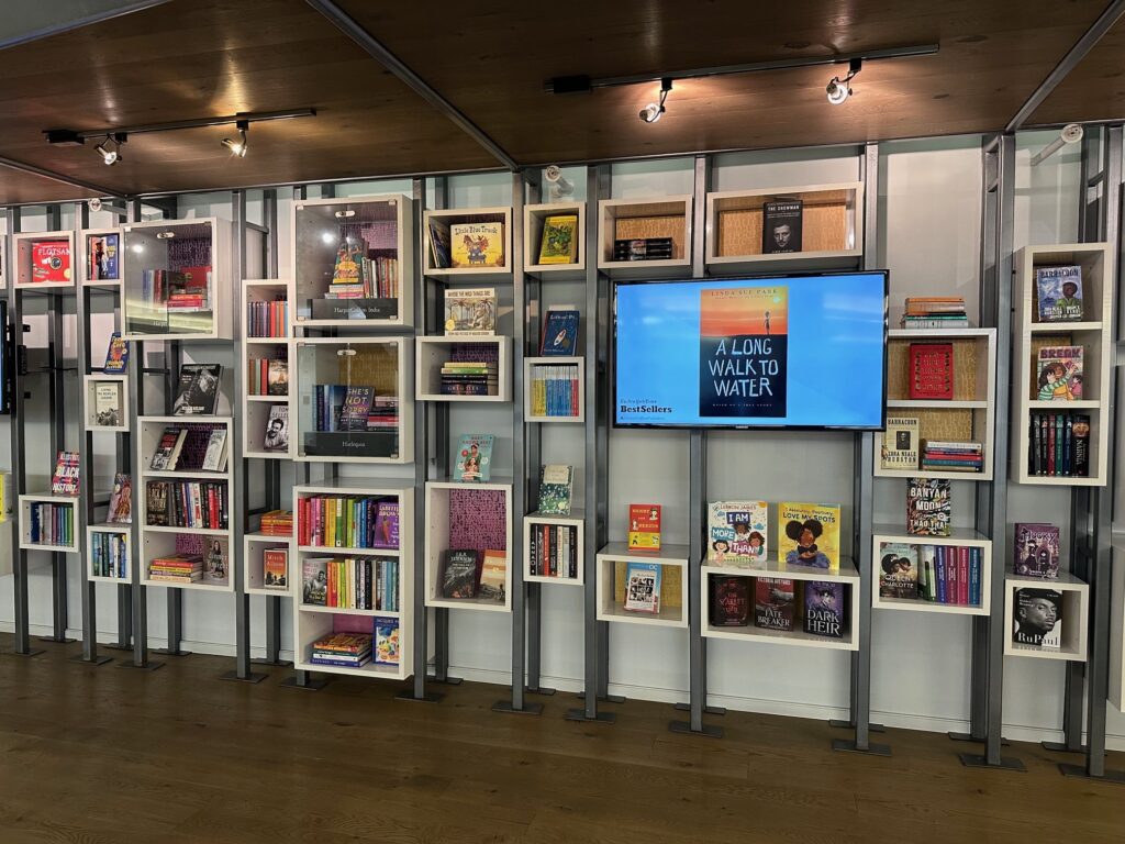 A white wall of different sized cubes which are filled with books
