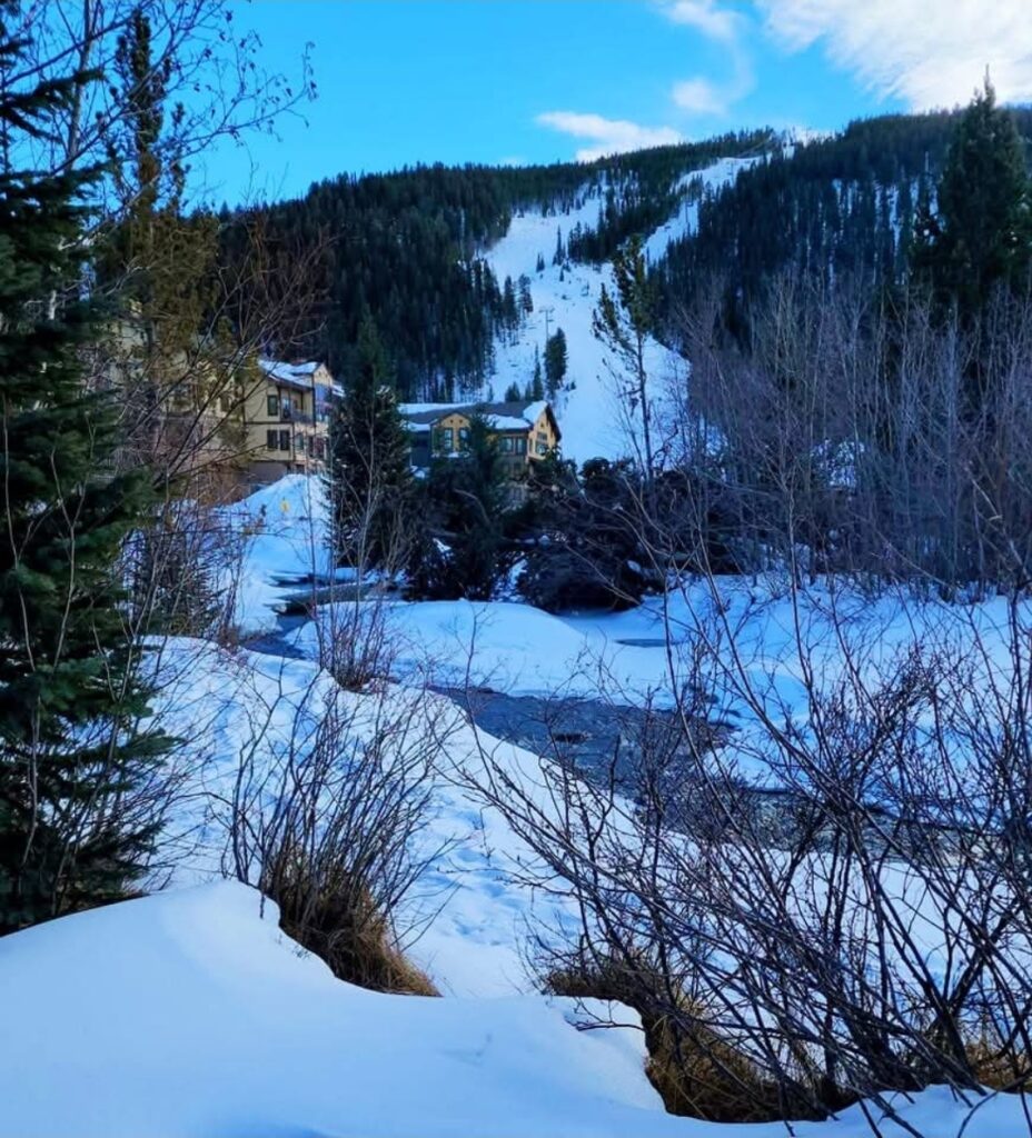 A winter vista of a snowy mountain and lodge